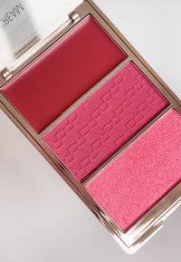 Palette de rubor que incluye tres tonalidades: crema rojo profundo, polvo rosa texturizado con un patrón y un suave brillo rosa. Compacto con un acabado reflectante.