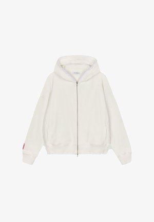 Valge lukuga kapuutsiga sviiter, millel on pehme tekstuur, laiad varrukad, soonikkoes mansetid ja äär, ning voodriga kapuuts. Vasakul varrukal on väike logo silt.