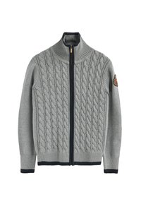 Szary sweter z dzianiny z wzorem w warkocze, wysokim kołnierzem, pełnym zamkiem błyskawicznym oraz granatowymi akcentami na mankietach i dole, z emblem na rękawie.