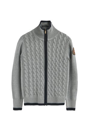 Suéter gris de punto con diseño de trenzas, cuello alto, cremallera completa y detalles en azul marino en los puños y el dobladillo, con un emblema en la manga.