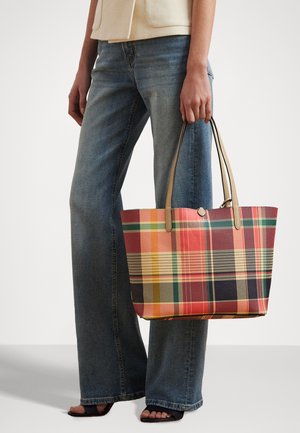 Plaid tote bag in red, orange, yellow, green, and navy, with two tan handles. Made of durable material, featuring a rectangular shape.