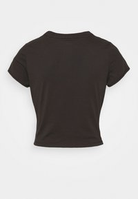 Camiseta negra de manga corta y corte corto, hecha de algodón suave. Presenta un cuello redondo y una textura lisa. Sin patrones ni elementos metálicos visibles.