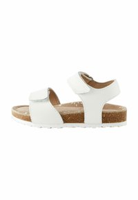Vit sandal med två justerbara kardborremmar, korkfotbädd och strukturerad gummisula. Rent utformad utan några ytterligare mönster eller accentuerade detaljer.