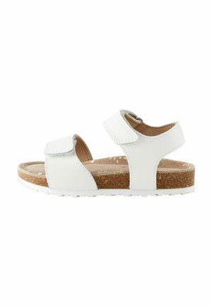 Vit sandal med två justerbara kardborremmar, korkfotbädd och strukturerad gummisula. Rent utformad utan några ytterligare mönster eller accentuerade detaljer.
