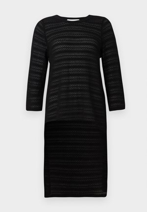 Melnā adīta kleita ar trim ceturtdaļām garām piedurknēm, ar teksturētu svītru rakstu. Apaļa dekoltē un ceļa garuma siluets.