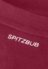 Tessuto di cotone borgogna con texture a coste; presenta la scritta "SPITZBUB" stampata in bianco. Vista ravvicinata che mette in risalto il collo e i dettagli del materiale.