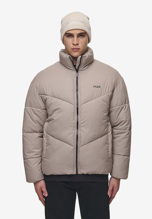 Beige puff jakke med chevron-syninger, høj krave og lynlås foran. Begge dele ledsages af en beige strikket hue med logodetalje.