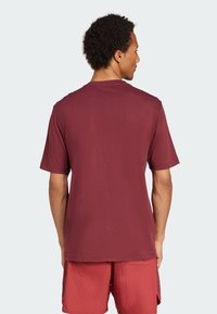 Bordo majica s kratkimi rokavi z okroglim izrezom, gladke teksture in sproščenega kroja, prikazana s hrbtne strani.