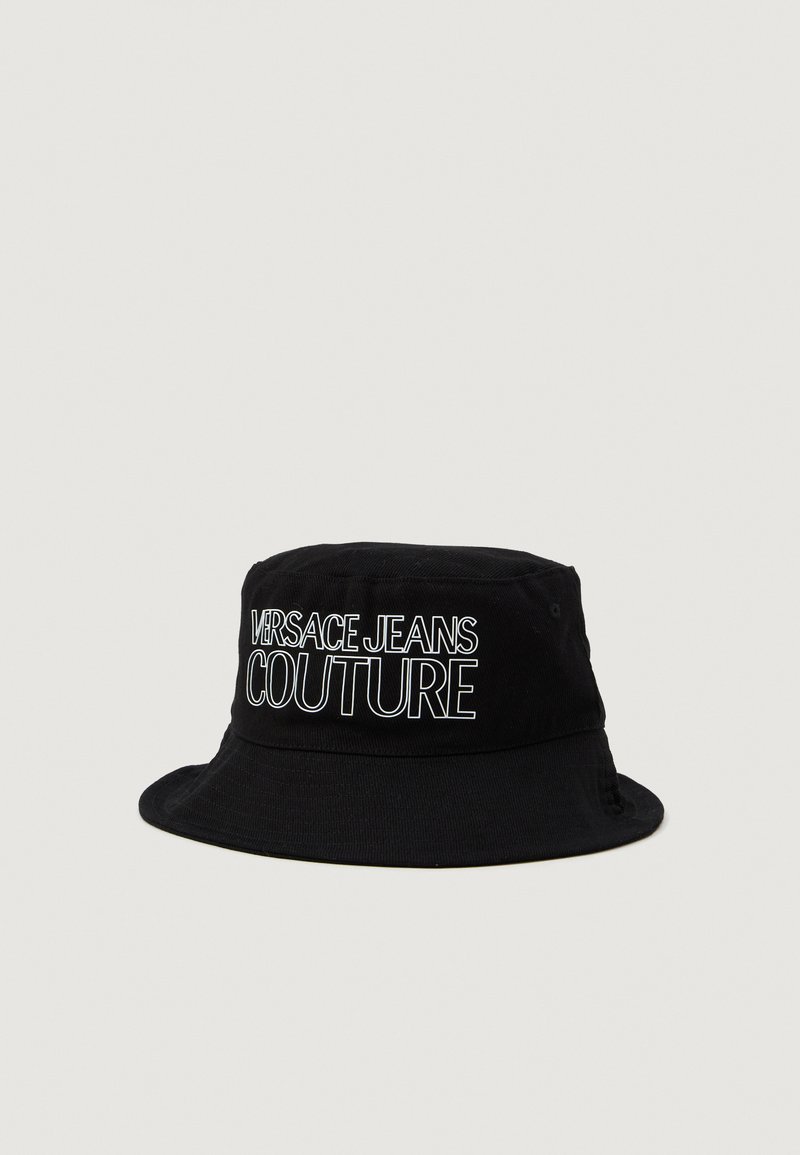 Crni šešir s širokim rubom od pamuka s mekanom teksturom. Ima bijeli izvezeni logo "VERSACE JEANS COUTURE" sprijeda.