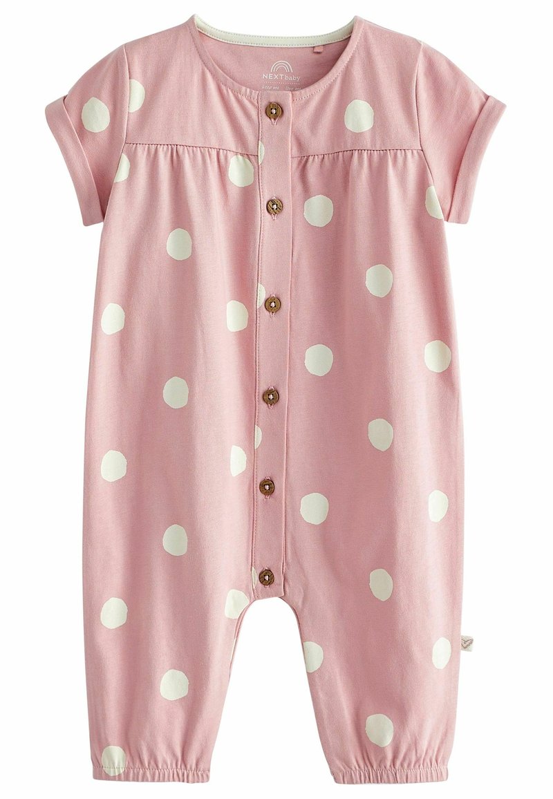 Combinaison bébé rose pâle à manches courtes avec des pois blancs, fermeture à boutons sur le devant et poignets élastiqués aux ouvertures des jambes.