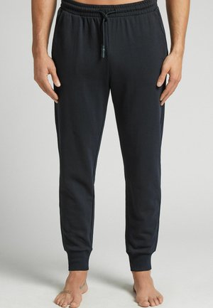 Zwarte sportieve joggers met een elastische tailleband, verstelbare koord, taps toelopende benen en textuurstof. Voorzien van zijzakken.