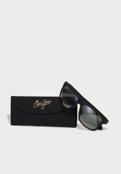 Occhiali da sole neri Maui Jim con lenti grigie, montatura rettangolare e finitura opaca, accompagnati da una custodia nera con dettagli in logo dorato.