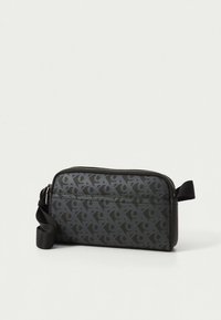 Borsa clutch nera con motivo a fantasia, dotata di chiusura con cerniera, una texture liscia e una tracolla regolabile. Il design include sottili accenti con il logo.