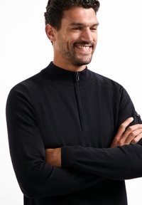 Zwart kwart-rits sweatshirt van zacht, gestructureerd materiaal met ribbelkraag en -manchetten; heeft een rits en een subtiele logoaccent.