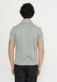 Polo shirt a maniche corte di colore grigio chiaro, realizzato in tessuto traspirante, con colletto classico e vestibilità rilassata. La vista posteriore mostra una texture liscia.