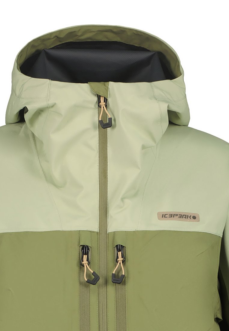 Kapuzenshirt in hellgrün und dunkelgrün, aus einem glatten Material gefertigt. Verfügt über einen Frontreißverschluss und verstellbare Kordeln.