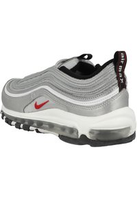 Nike Air Max med en slank grå ovandel, vita detaljer, röd logotyp, texturerad vågig design och en synlig luftkuddenhet i sulan.