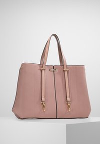 Sac cabas en cuir rose poussiéreux de taille moyenne avec double poignée, ferrures dorées et coutures verticales, présenté sur un fond blanc uni.