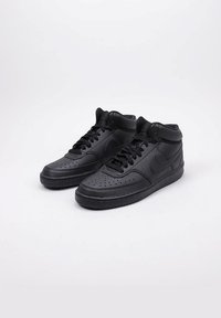 Sneakers neri alto in pelle, con punta forata, lacci neri e suola texturizzata con un logo discreto sul lato.
