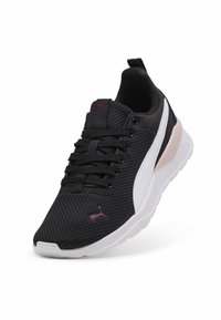 Baskets de sport noires en mesh avec des accents blancs et roses, bout rond, six œillets ronds et une semelle en caoutchouc texturée. Présente un logo sur le côté.