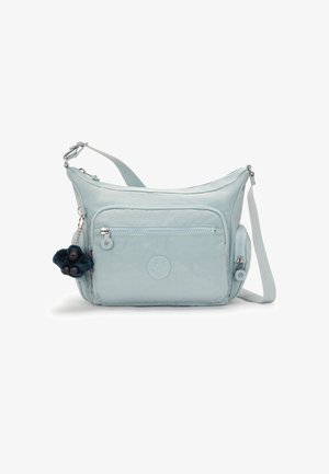 Light blue shoulder bag made of soft fabric, featuring a front zip pocket, logo detail, and a detachable furry keychain accent.