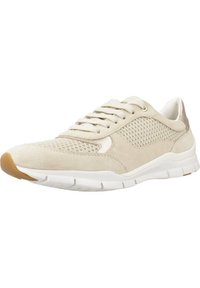 Zapatilla de gamuza beige con paneles de malla, suela de goma blanca y punta redonda. Presenta un diseño de cordones y un acento metálico en el talón.
