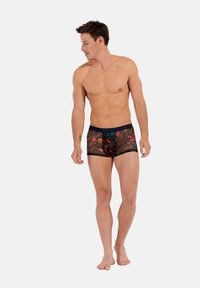 Schwarze Netz-Boxershorts mit buntem Blumenmuster und einem marineblauen elastischen Bund. Die strukturierte Optik hebt die lebhaften Farben und Muster hervor.