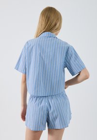 Blue and white striped short-sleeve shirt with collar, elastic waistband shorts, cotton material, smooth texture, and casual fit.