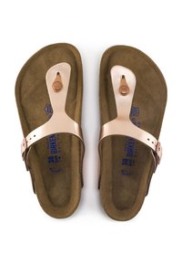 Sandales en daim marron avec une lanière en métal bronze et une boucle réglable. La semelle intérieure arbore un marquage bleu et une forme contourée.