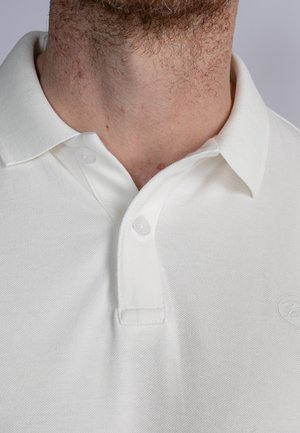 Cămașă polo albă dintr-un amestec texturat de bumbac, având un guler ribflat, închidere cu două butoane și un logo subtil pe piept.