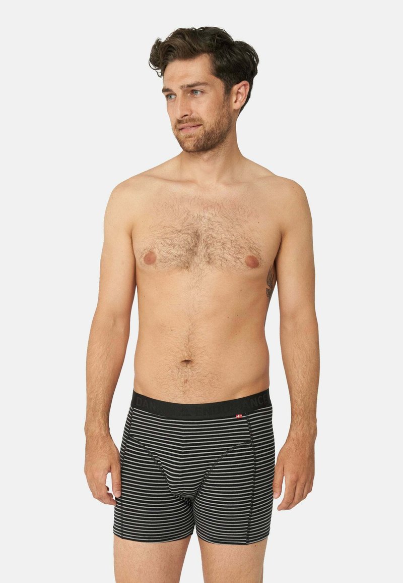 Boxer shorts a righe bianche e nere con una vita nera, caratterizzati da un logo e una vestibilità aderente, realizzati in tessuto morbido e elastico.