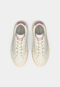 Pair of white low-top Converse All Star sneakers with cream soles and light purple accents, shown from above on a white background.