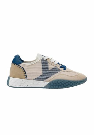 Sneaker beige e bianca con dettagli blu, pannelli in mesh, lacci bianchi e blu e suola blu testurizzata con intersuola maculata.