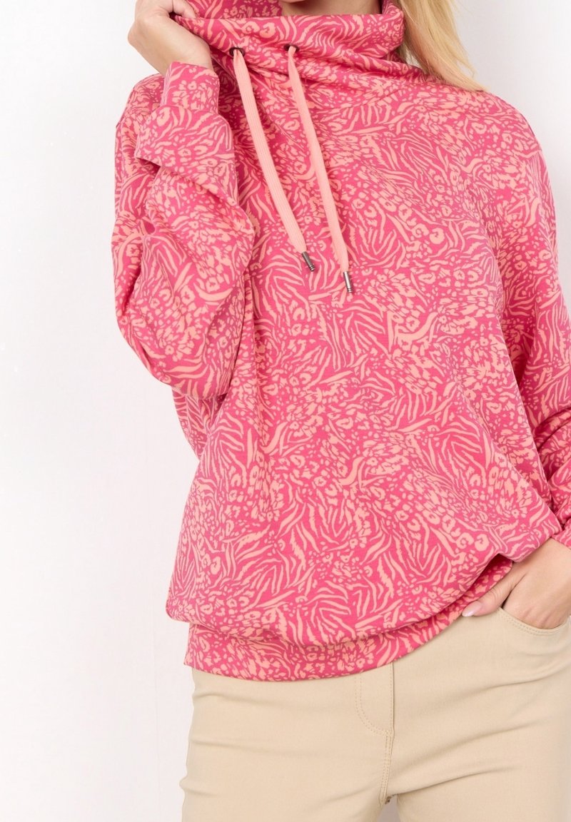 Pink hoodie with a floral and zebra print pattern, funnel neck, and drawstring accents. Cozy fabric and relaxed fit.