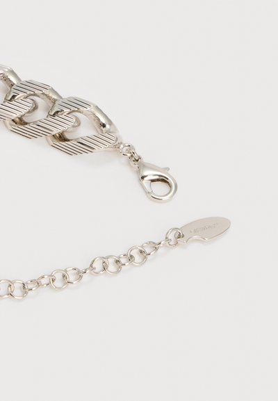 Ασημένιο βραχιόλι αλυσίδας με υφή σε μεγάλα κρίκους και κούμπωμα τύπου αστακού, διαθέτοντας ρυθμιζόμενη επέκταση αλυσίδας και μικρή ετικέτα.