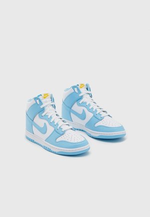 Paar weiße und hellblaue Nike High-Top-Sneaker mit weißen Schnürsenkeln und gelbem Nike-Logo auf der Zunge, dargestellt auf einem einfarbigen hellen Hintergrund.