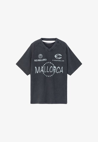 T-shirt noir à manches courtes et col en V avec des logos blancs et le texte RCD Mallorca, Camperlab et Mallorca entourés d'étoiles.