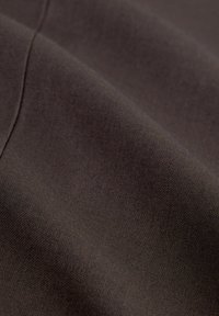 Donkerbruin stof met een gladde textuur en subtiele glans, met een uniforme weefpatroon en zachte plooien.