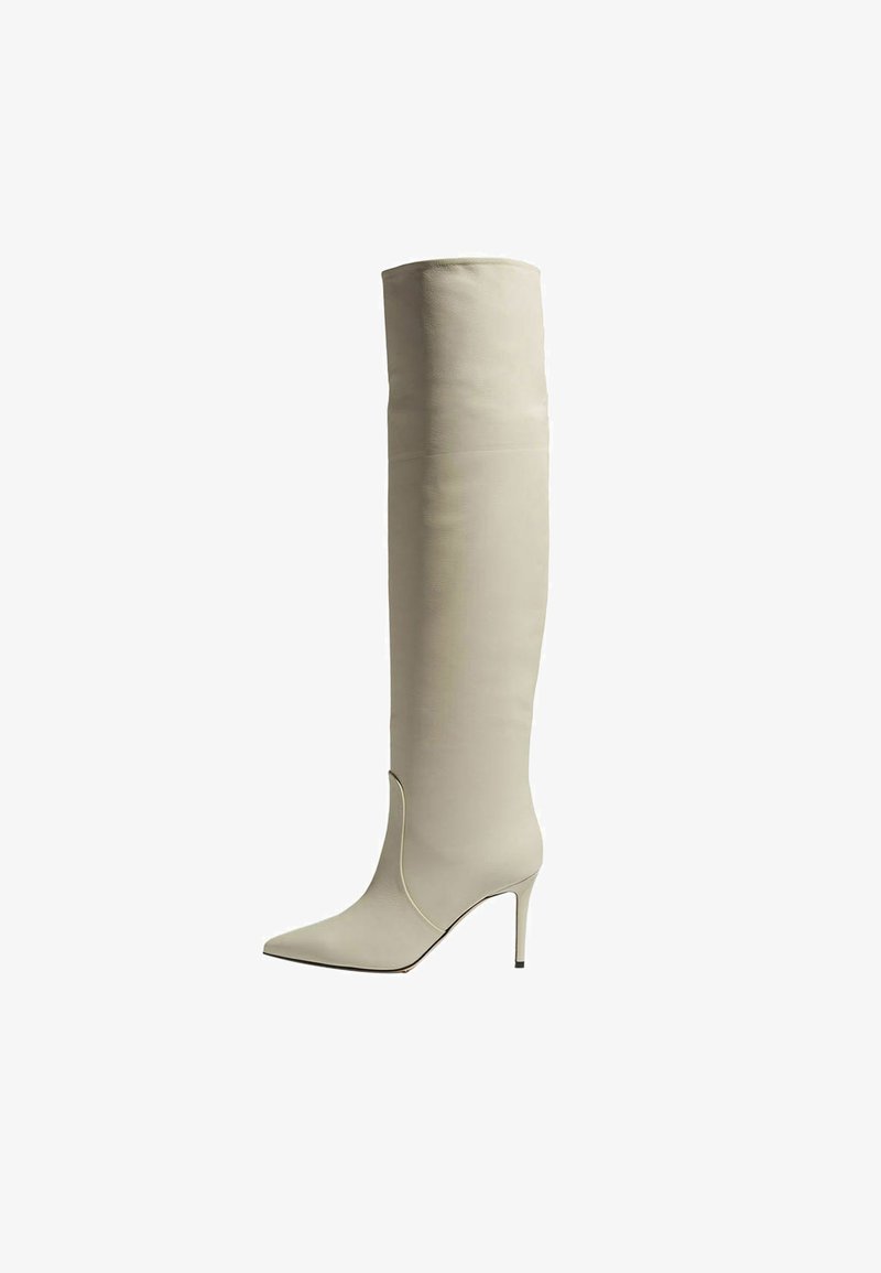 Bota de tacón stilettos de cuero blanco roto hasta la rodilla, con puntera afilada y un diseño de costura mínimo. Textura suave, silueta elegante y tacón elevado.