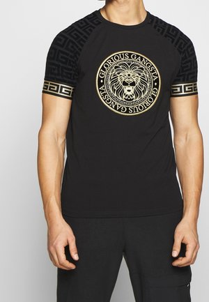 T-shirt nera a maniche corte, con una grafica circolare dorata di un leone e intricati motivi neri e dorati sulle maniche.