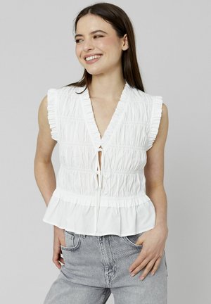 Haut sans manches blanc avec un décolleté en V, bordure froncée, texture plissée et détail à nouer à l'avant ; ourlet peplum et accents de volants subtils.