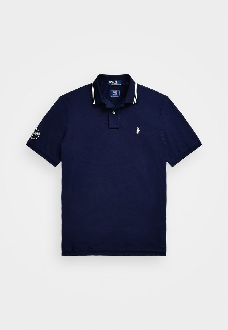 Marineblå polo skjorte laget av bomull, med tre-knaps placket, hvitstripet krage, korte ermer og brodert logo på brystet.