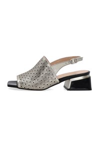 Metallisch silberner Slingback-Schuh mit geometrischem Durchbruchsdesign, offener Zehenpartie und Blockabsatz. Verfügt über detaillierte Akzente und eine strukturierte Oberfläche.