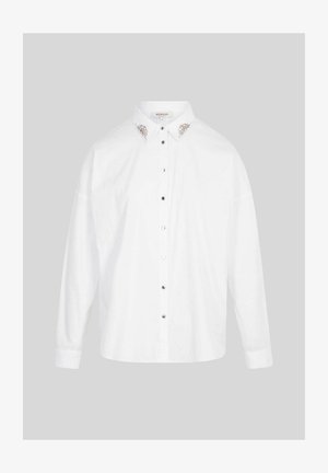 Camisa blanca de manga larga con botones y adornos de plata y perlas en el cuello, exhibida sobre un fondo gris liso.