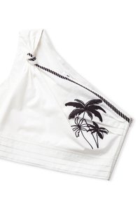 Witte top met één schouder, versierd met zwarte palmboom borduursels en een knoopdetail op de schouder. Heeft een gestructureerde zoom met verticale strepen.