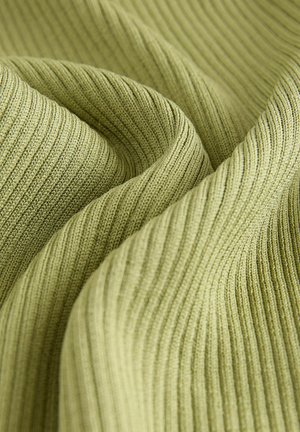 Close-up svetlozelene rebraste pletene tkanine z vidno teksturo in gubami.