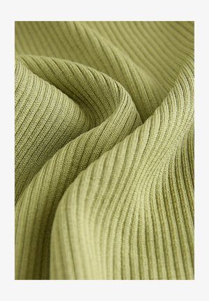 Close-up svetlozelene rebraste pletene tkanine z vidno teksturo in gubami.
