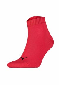 Red ankle sock made of stretchy material with ribbed cuff and black logo detail. Smooth texture with a rounded toe design.