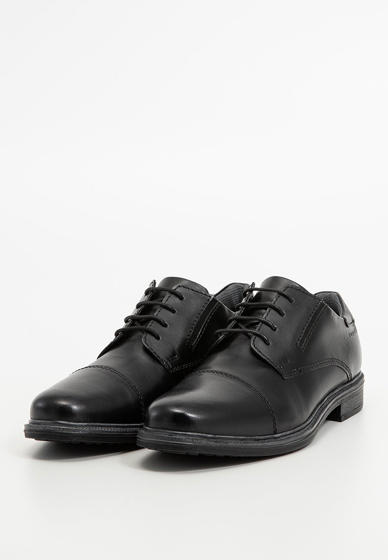 Chaussures habillées en cuir noir avec une finition lisse, bout rond, design à lacets et un petit talon en caoutchouc. Détails de couture subtils sur les côtés.