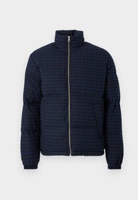 Mørkeblå pufferjakke med rutet mønster, høy krage, frontglidelås og sidelommer. Designet har en teksturert overflate.